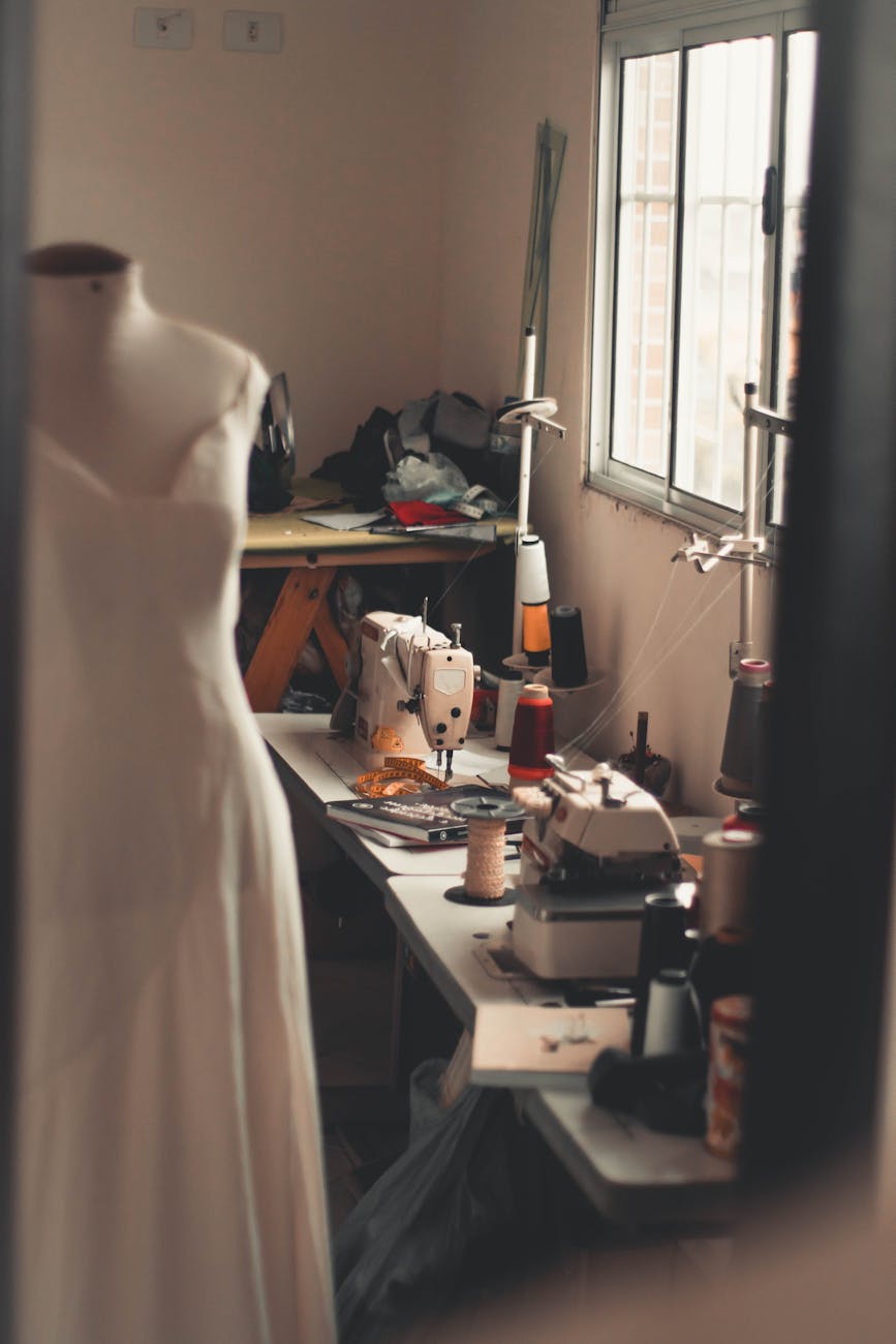 white dress on mannequin beside white sewing machine